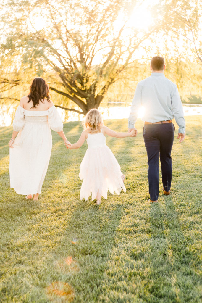 Family of three walking off into the sunset at a maternity session at coxhall gardens in carmel indiana