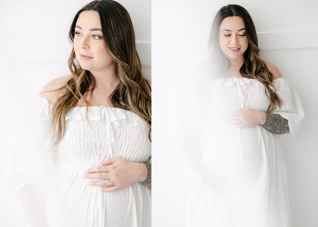 Indianapolis Maternity photography session in light and airy studio, mother holding baby bump while wearing a white dress