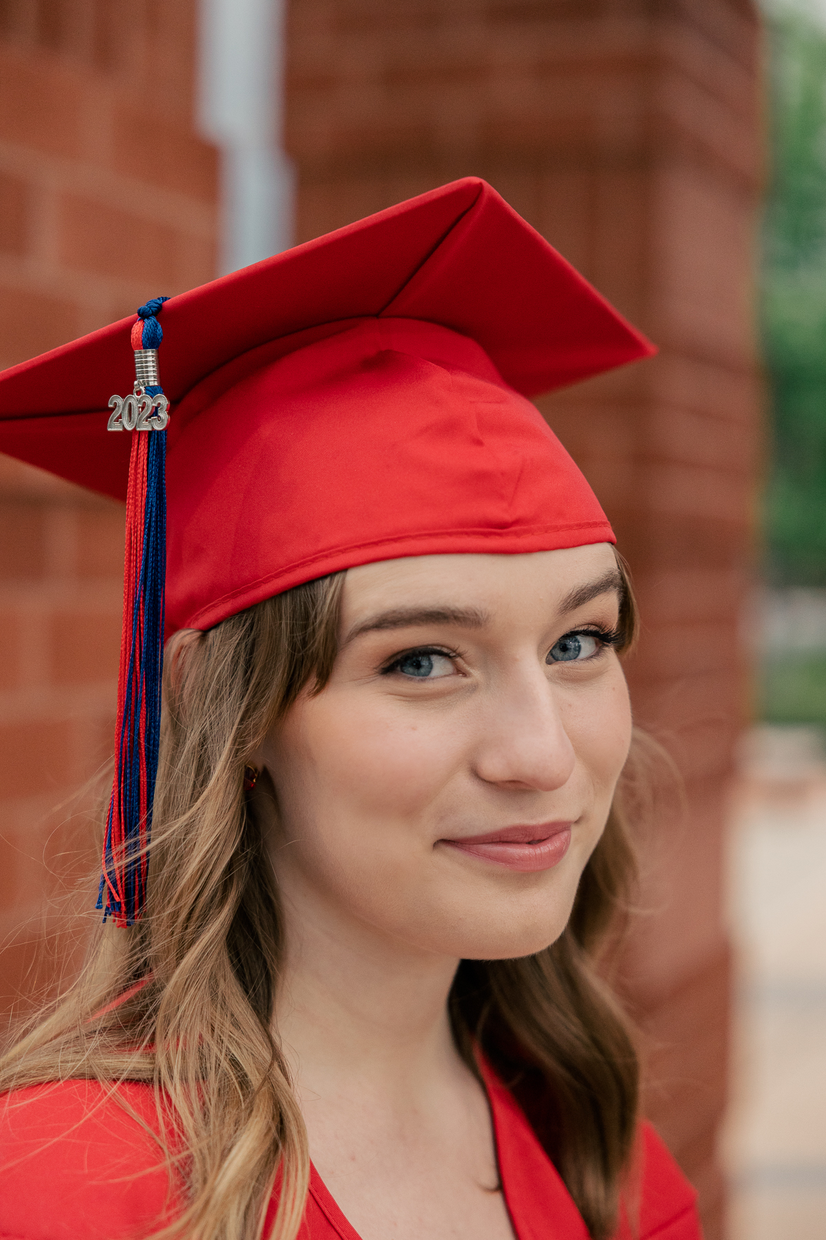 close up of girl in red graduation cap smiling at camera, Plainfield senior photography