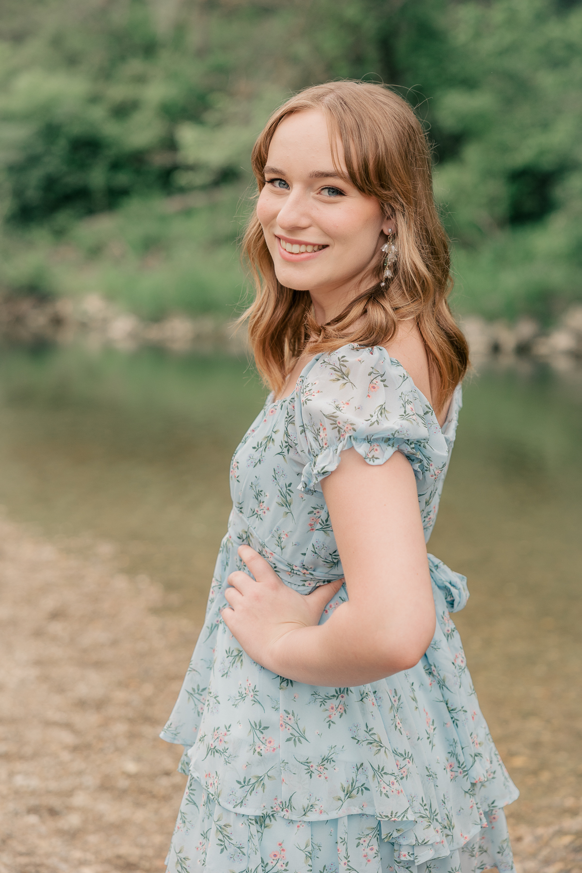 girl in blue floral dress poses by creek, Plainfield senior photography