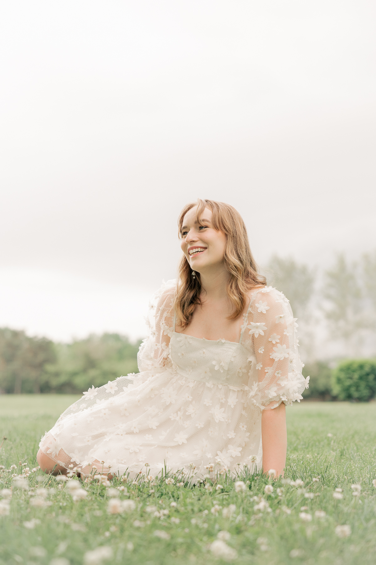girl in puffy white dress sits in field with white flowers, cottagecore, Plainfield senior photography
