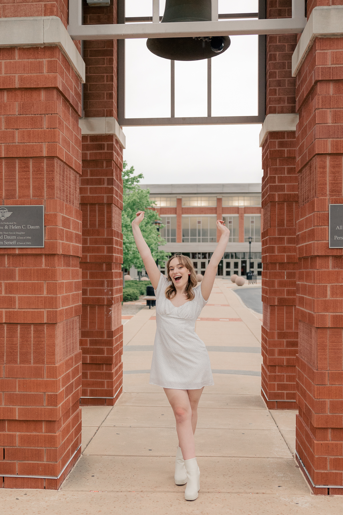 girl in white dress throws her hands up to celebrate, Plainfield senior photography