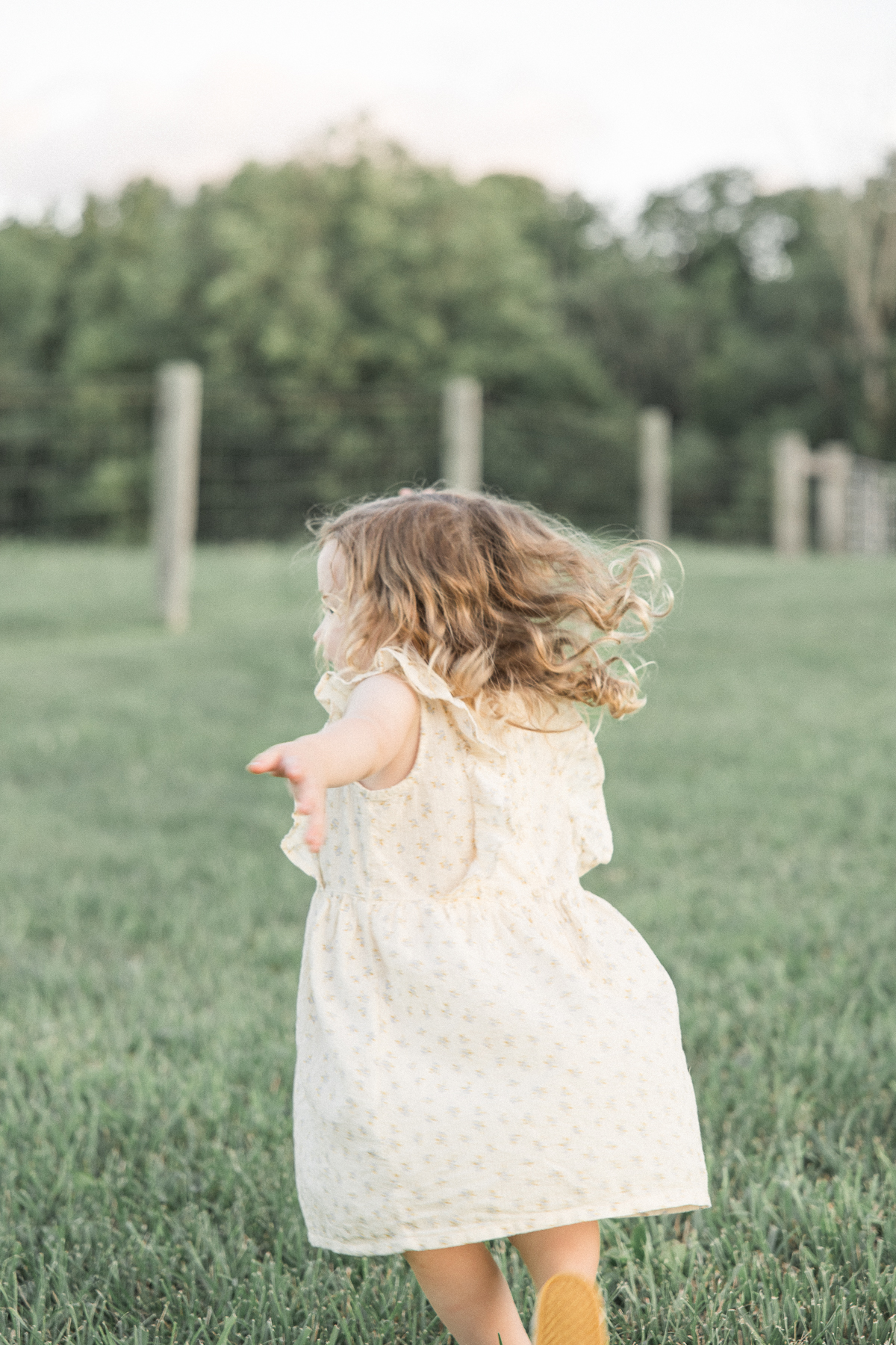 Toddler girl runs in a grassy field at Trader's Point Creamery indianapolis baby shower venues
