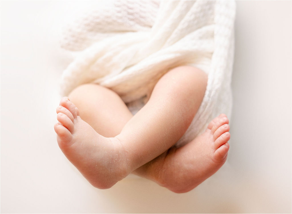 Details of a newborn baby's feet while wrapped in a swaddle