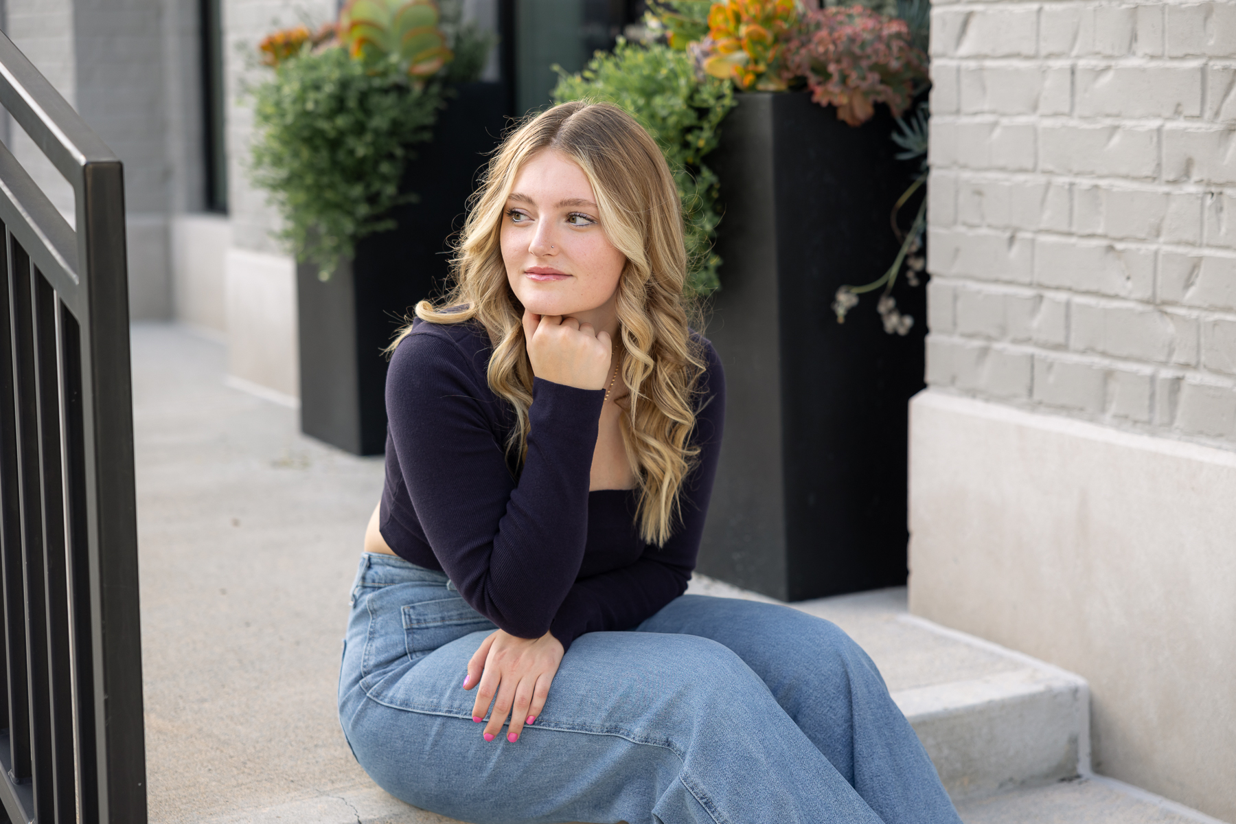 high school girl sits on steps and looks off in the distance, Carmel senior pictures