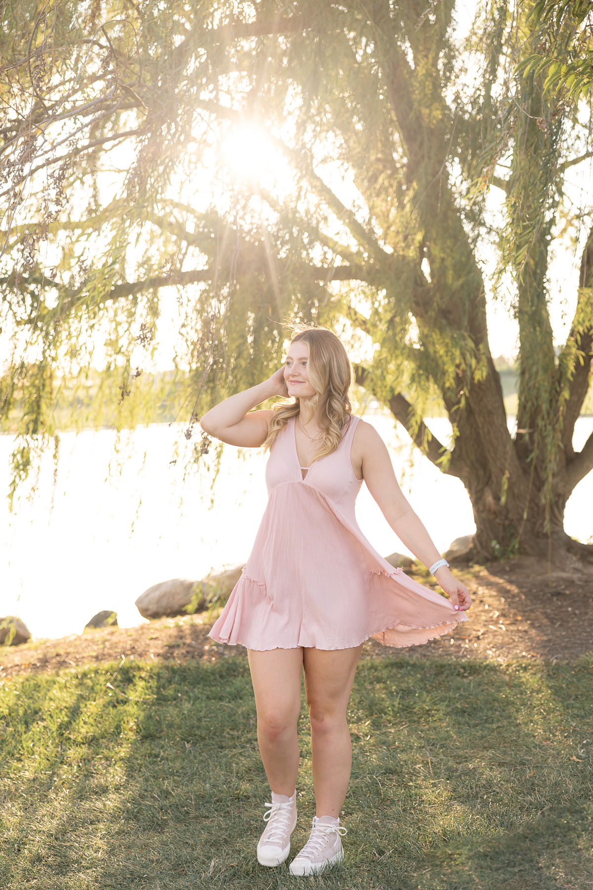 Girl twirls in pink dress in front of a willow tree at sunset, carmel senior pictures