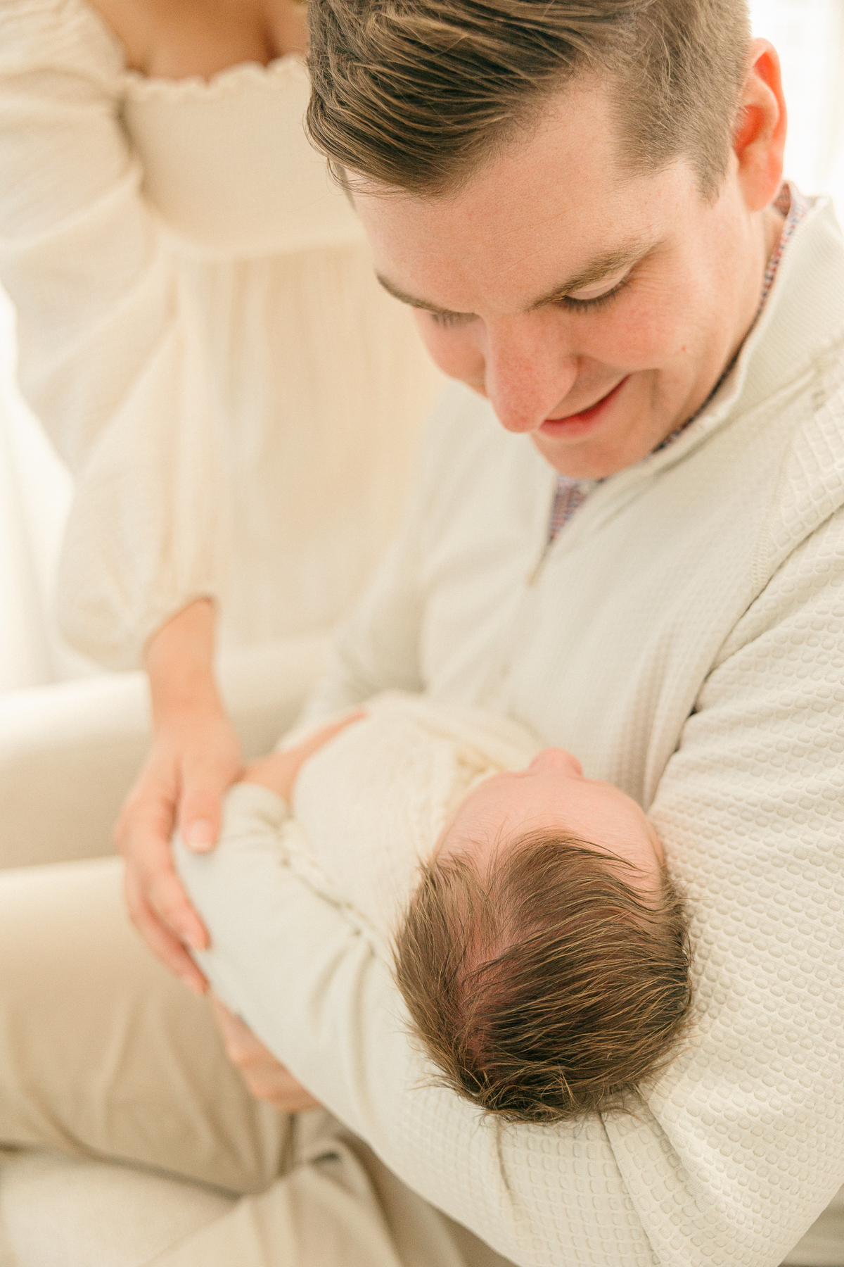 father holds newborn and smiles down at him, Indianapolis newborn Photographer