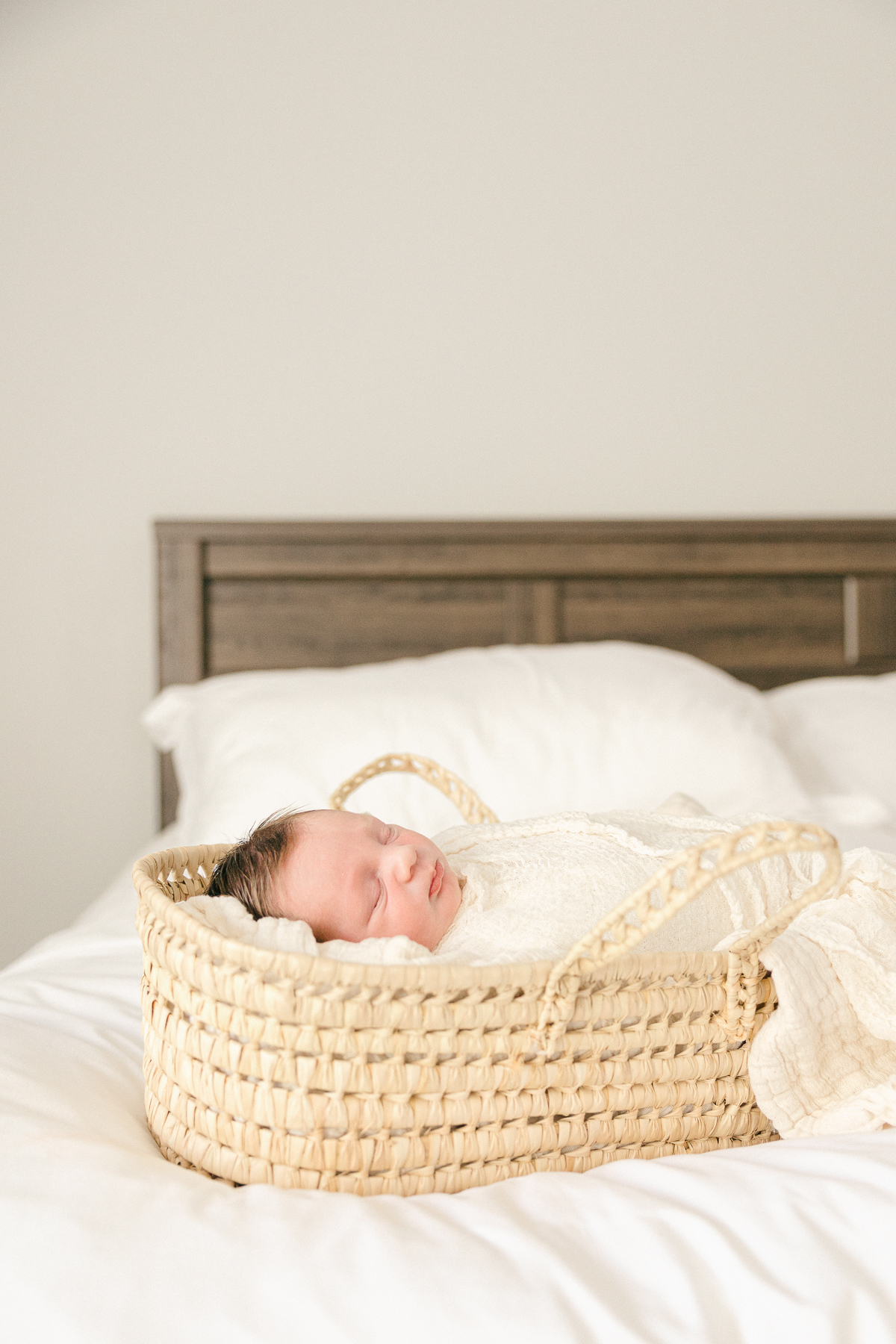 Baby boy swaddled in cream in moses basket on a bed, Indianapolis Photographer