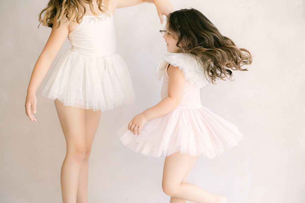 Sisters in white and pink tutus twirl during mommy and me classes in Indianapolis