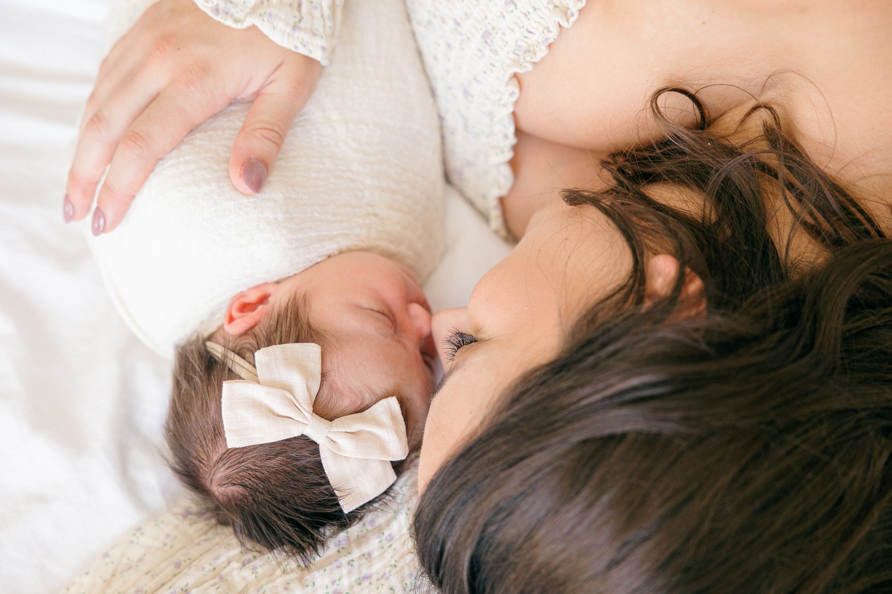 mother and baby touch noses while lying next to eachother, Fishers newborn photographer