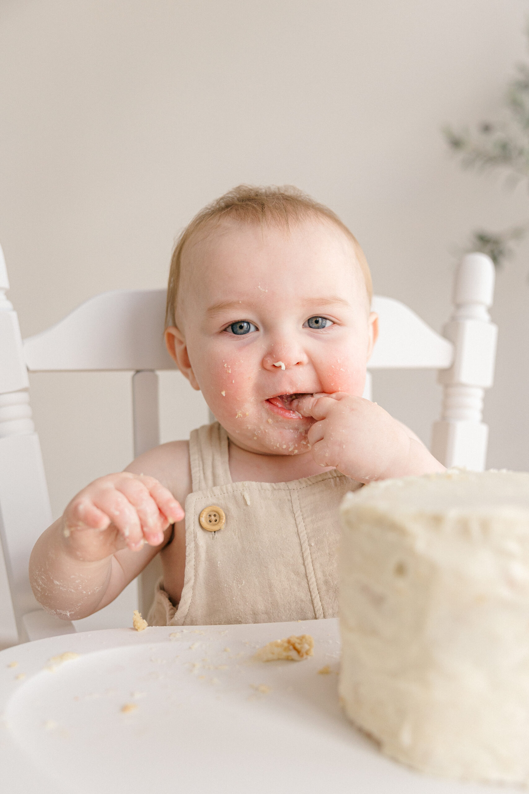 Baby boy sitting in a white highchair eating with his finger in his mouth, kid-friendly restaurants in Indianapolis 