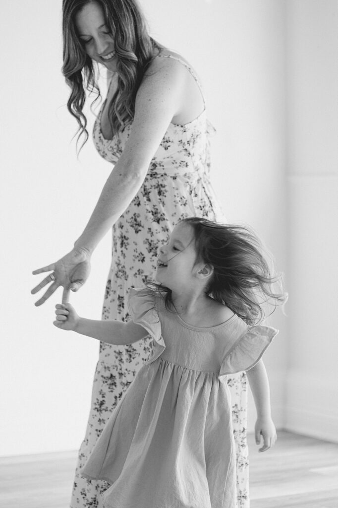 Black and white image of a mother twirling her daughter during mommy and me classes in Indianapolis